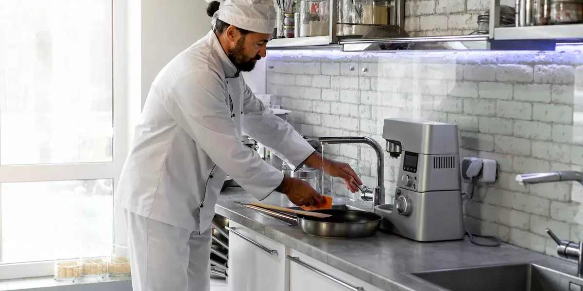 cocina industrial limpia cocinero fregando en una cocina industrial limpia